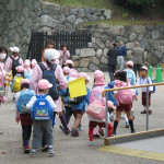 School children tour the school in uniforms and masks.