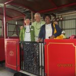 Barbara and Jim N. and Dorothy J. posed with a restored train car at Friendship Grove Botanical Gardens. Barbara and Jim N. and Dorothy J. posed with a restored train car at Friendship Grove Botanical Gardens.