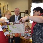 On behalf of the delegation, Natalia presented the mayor with several gifts including a map of Moldova. Mariana helps show the mayor the location on the map of Chisinau, the capital city. On behalf of the delegation, Natalia presented the mayor with several gifts including a map of Moldova. Mariana helps show the mayor the location on the map of Chisinau, the capital city.