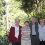 Barbara and Jim N. with their hosts pose in front of Kitekite Falls.