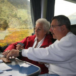 Sara teaches the game of cribbage to Ray K. while riding the Trans-Alpine Express.
