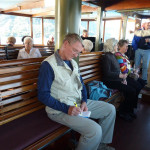 Charlie F. takes a moment to update his notes while riding on a steamboat.